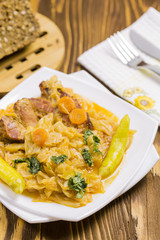 Cooked Cabbage with Carrots, Hot Peppers, Parsley, Integral Sunflower Bread on Brown Wooden Table