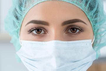 Close-up portrait of female medicine doctor wearing protective m