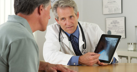 Doctor consulting senior patient about his xrays