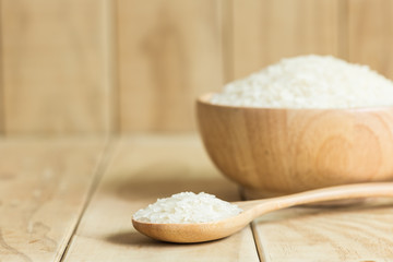 Thai jasmine rice in wooden spoon on wooden background