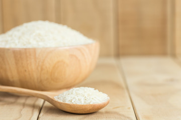Fototapeta na wymiar Thai jasmine rice in wooden spoon on wooden background