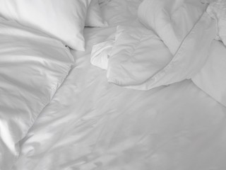 Detail of bed with set of crisp white sheets and pillows