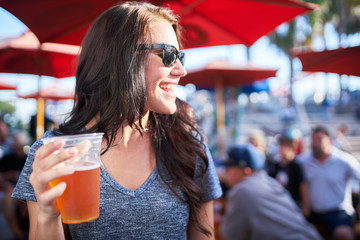 woman with beer at outdoor bar or restaurant patio - Powered by Adobe