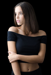 Beautiful brunette girl in black clothes isolated on black background
