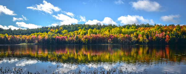 Colorful reflections on the lake in September. - 94981989