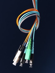 A bundle of three fiber optic patch cords with connectors arranged in a knot on black background, Australia 2015 - 94982974