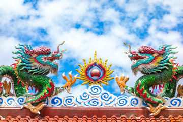 Fototapeta na wymiar Two dragon on red roof with cloudy blue sky, Chinese temple in T
