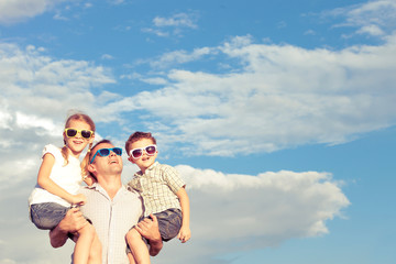 Father and children playing in the park  at the day time.