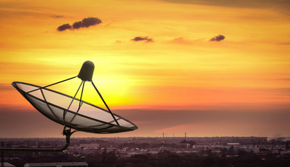 Fototapeta na wymiar Satellite dish in the city on sunset.