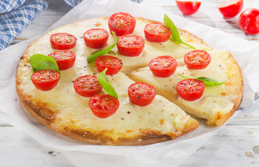 Italian Pizza Margherita with cheese and tomatoes on wooden boar