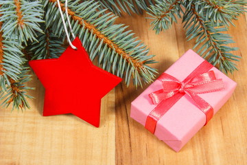 Spruce branches with red wooden star and gift for Christmas
