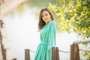 Portrait of slender beautiful girl on the blurry background of the river