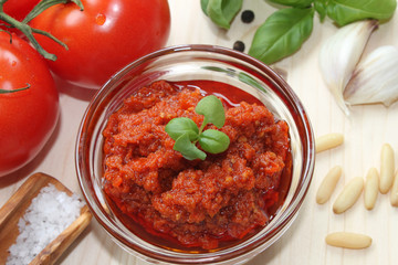 homemade red pest with ingredients around and basil garnish