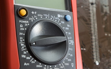 Fototapeta premium Red multimeter on motherboard background