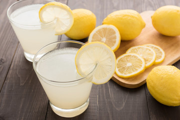 lemonade with fresh slice lemon on wooden table - obrazy, fototapety, plakaty