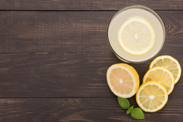 Fototapeta na wymiar lemonade with fresh slice lemon on wooden background