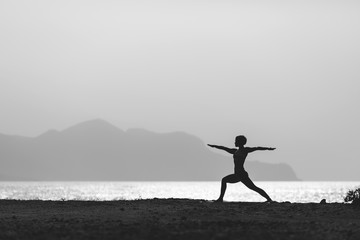Woman meditating in yoga pose silhouette