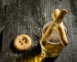 Cheese pastry and glass of light beer on light grey table. Selec