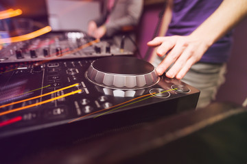 Club DJ playing mixing music on vinyl turntable