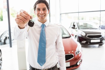 Fototapeta premium Salesman standing while offering car keys