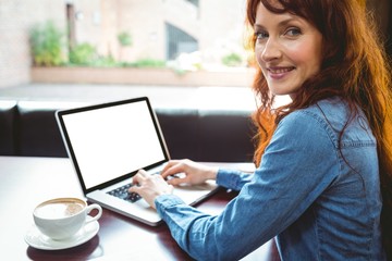 Mature student using laptop in cafe