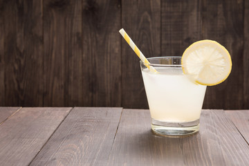 lemonade with fresh slice lemon on wooden background