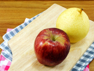 red apple and yellow chinese pear on wooden background