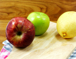 green apple yellow chinese pear and red apple on wooden background