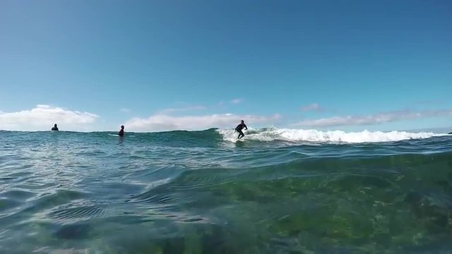 SLOW MOTION UNDERWATER: Young surfer girl surfing on a wave