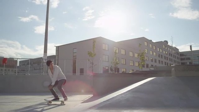 SLOW MOTION: Skateboarder riding and jumping in a skatepark