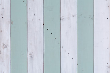 Green and white stripes painted on door to wooden beach hut