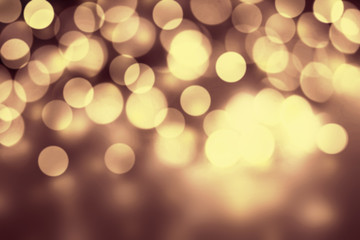 Gold Bokeh Christmas Background. Festive lights dark golden colo