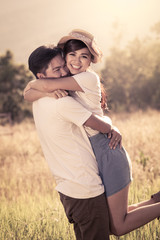 Young couple in love  in the meadow in vintage color filter