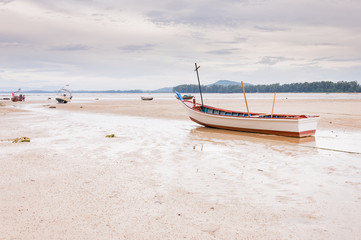 Fototapeta premium Abandoned old wooden boat on the beach in Phuket, Thaialnd