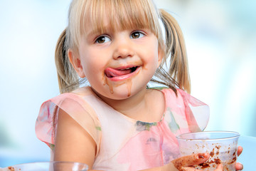 Little girl drinking chocolate milk at home.