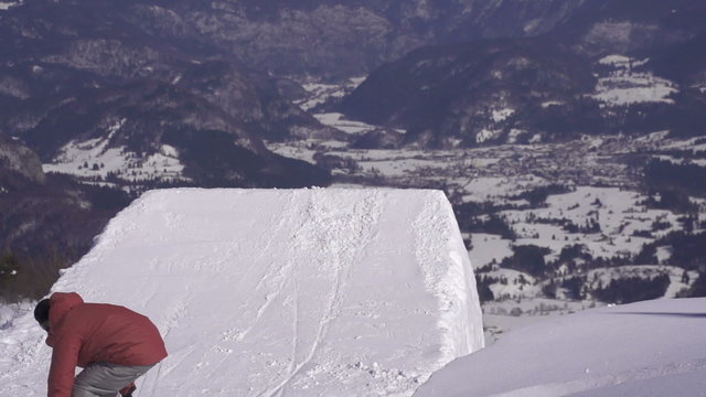 SLOW MOTION: Snowboarder jumps the kicker in winter