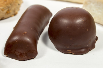 A shortbread bar covered by black chocolate beside a coconut bonbon. Spanish Christmas sweets