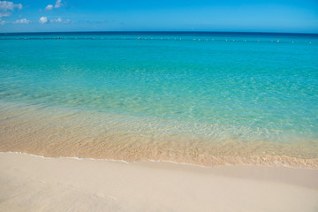 Fototapeta na wymiar Azure turquoise calm sea, clear blue sky, sandy beach and flat horizon