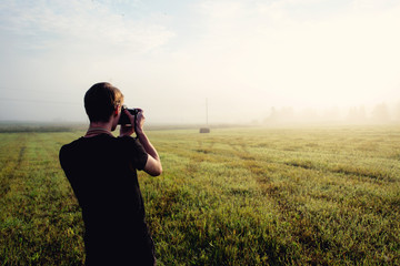 photographer in the fog taking a picture of the landscape