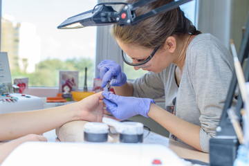 closeup of manicurist at work in the salon nail (shallow DOF; co