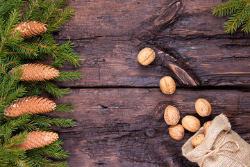 Fir cones and walnuts on a wooden background