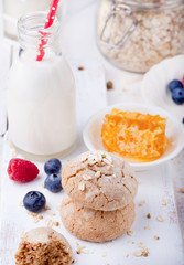 Gingerbread cookies with fresh berries and bottle of milk .