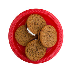 Oatmeal crème cookies on a red plate