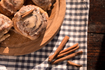 Cinnabon buns with cinnamon on a wooden board