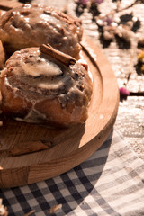 Cinnabon buns with cinnamon on a wooden board