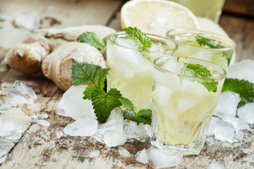 refreshing cold drink with ginger, lemon, ice and mint, selectiv