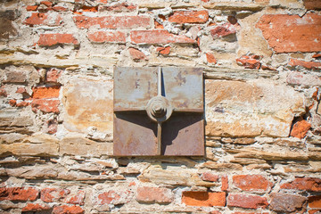Old brick wall reinforced with metal plates