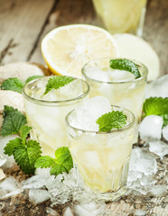 refreshing cold drink with ginger, lemon, ice and mint, selectiv