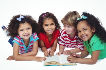 Four small kids reading a book together