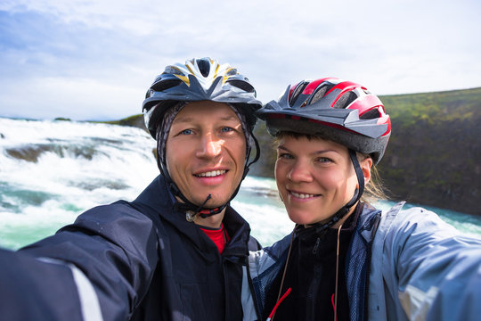 Happy bikers couple doing selfie on backdrop of Gulfoss waterfall